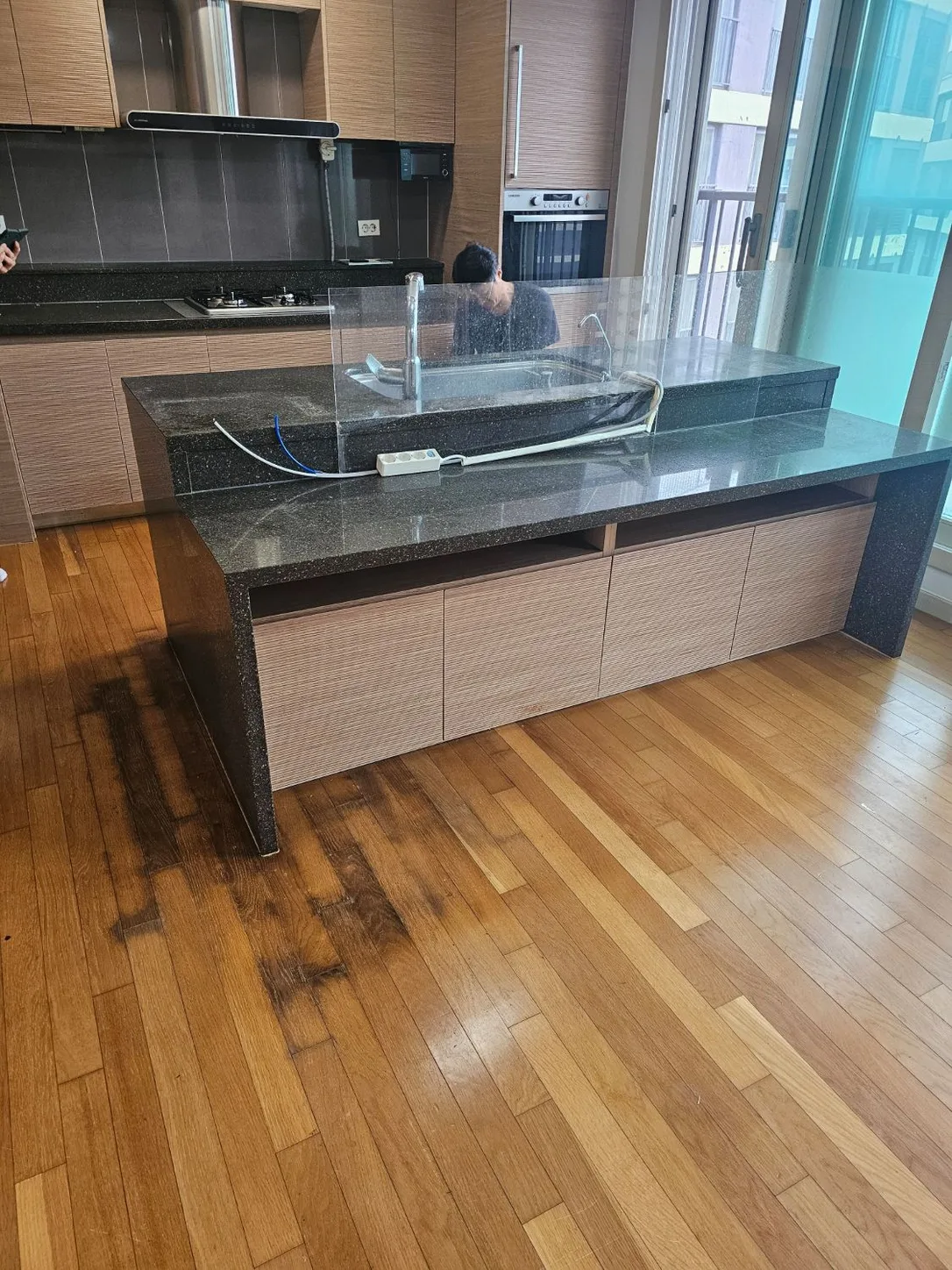 아일랜드 식탁 앞쪽 마루가 누수로 검게 변한 작업 전 모습